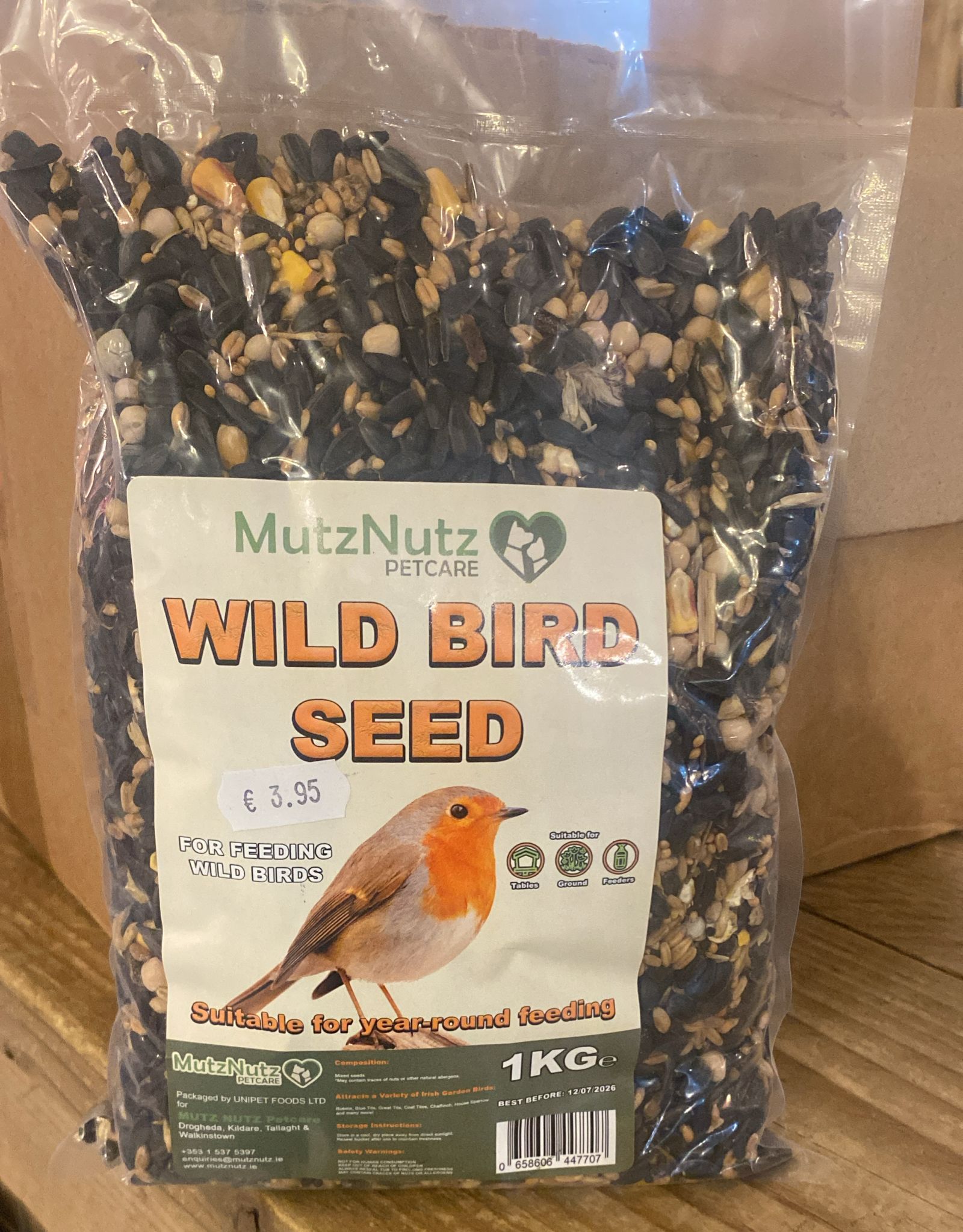 Bag of MutzNutz Wild Bird Seed with a label on a wooden surface